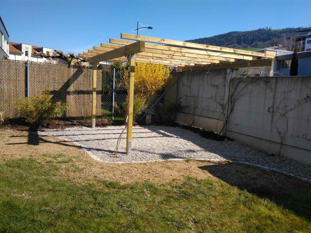 Gestaltungsidee für Gartengestaltung in St. Gallen: Holzpergola über einem Kiesplatz mit Bepflanzung